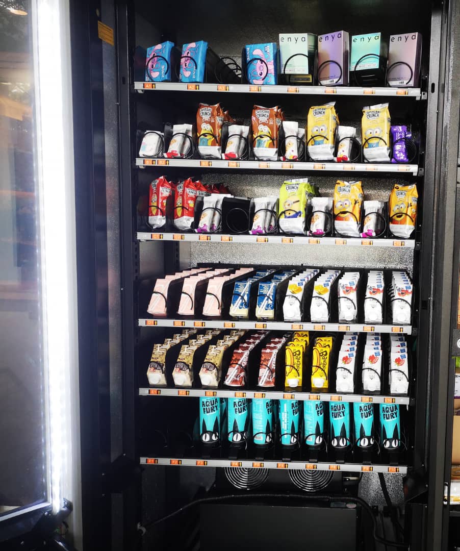Vending machine stocked with various snacks and drinks, including Aqua Fury